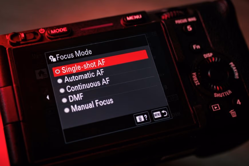 Camera LCD screen displaying the Focus Mode menu with AI autofocus options